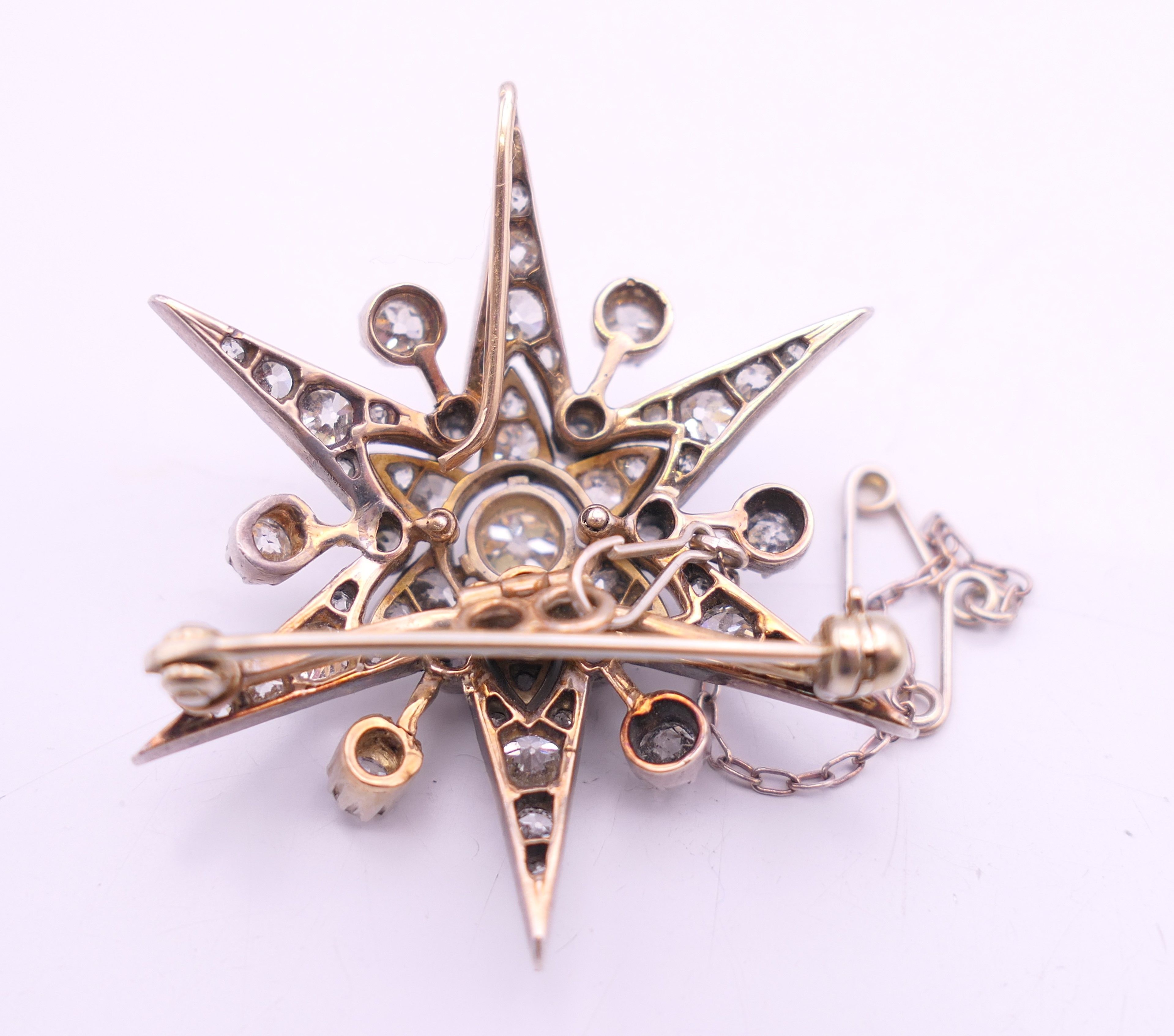 An unmarked gold diamond set star form pendant/brooch. 4 cm high. 10.7 grammes total weight. - Image 4 of 6