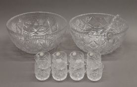 Two cut glass punch bowls, cups and a ladle. The largest 31 cm diameter.