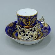 A Cauldon porcelain coffee can and saucer with silver mount. The can 6 cm high.