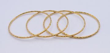 Four 22 ct gold bangles. 6 cm internal diameter. 53.1 grammes total weight.