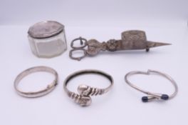 Three silver bracelets (37.6 grammes total weight), a silver topped glass jar and a candle snuffer.