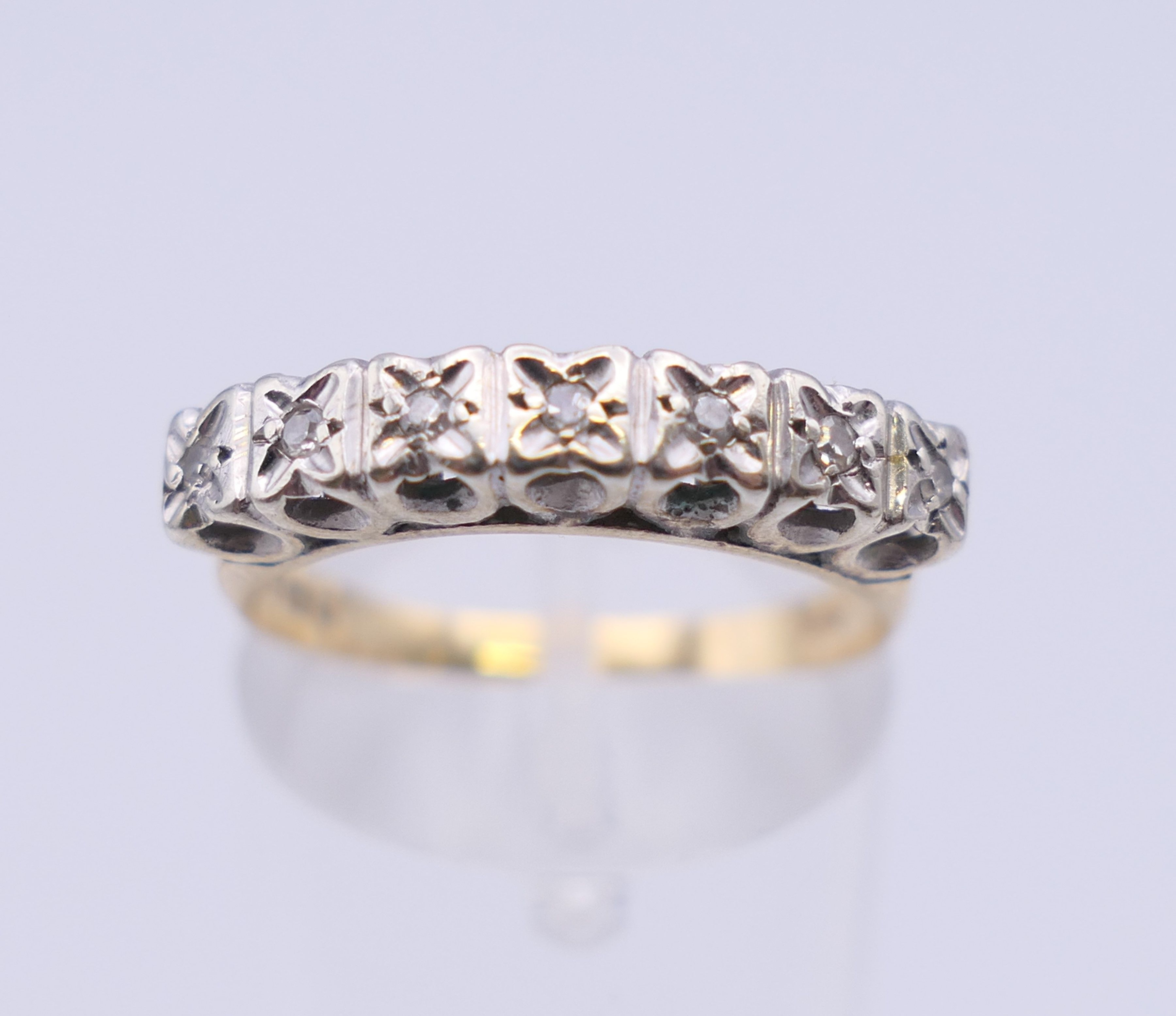 A 9 ct gold seven stone diamond ring. Ring size N/O. 2.5 grammes total weight.