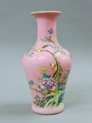 A Chinese pink porcelain vase decorated with birds amongst prunus blossoms. 24 cm high.