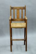 An Arts and Crafts oak child's high chair. 36.5 cm wide.