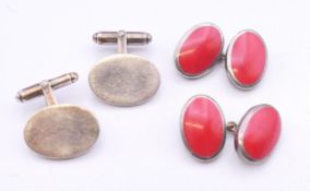 A pair of silver hallmarked cufflinks and a pair of red enamel cufflinks.