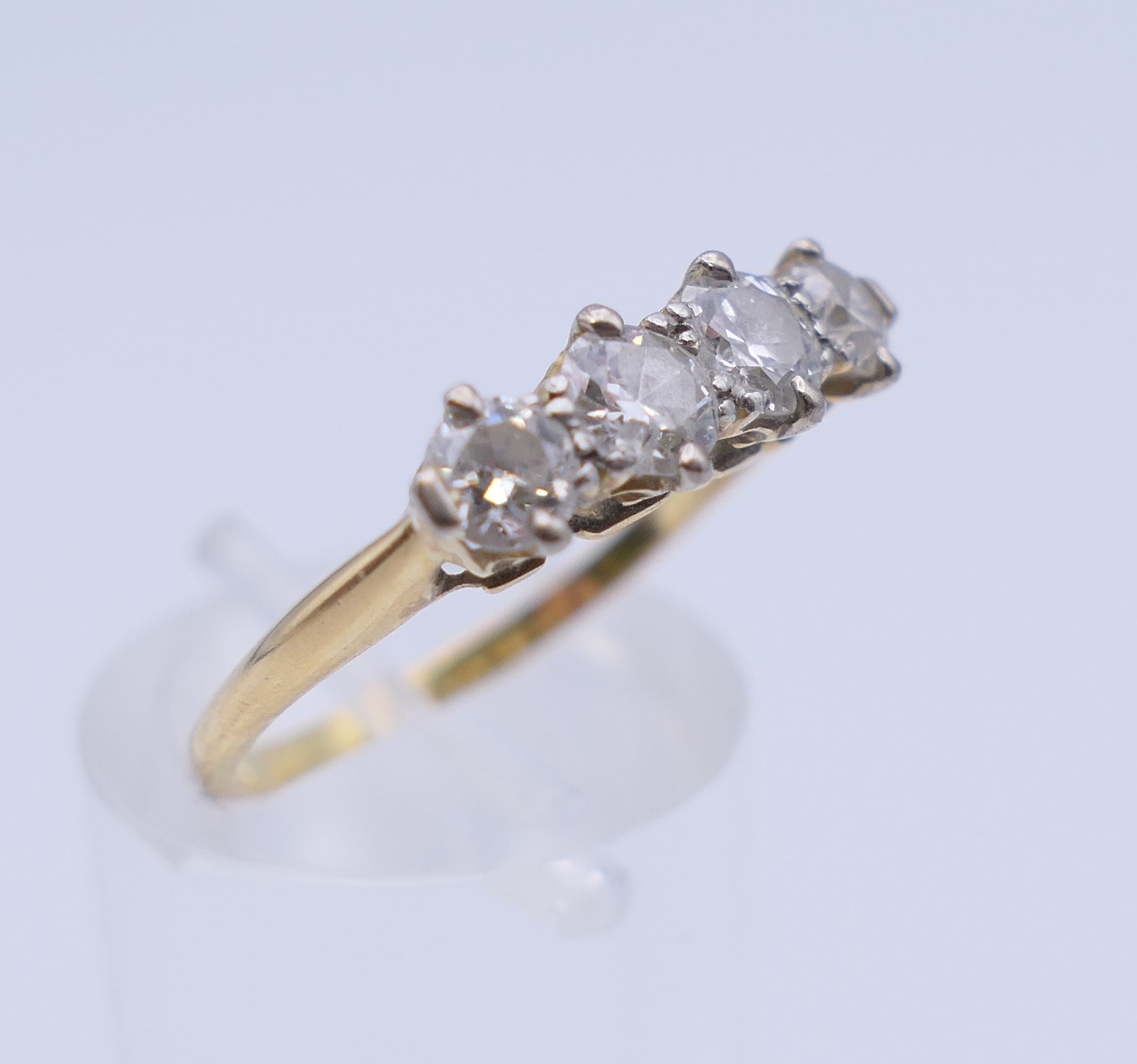 An unmarked gold four stone diamond ring. Ring size O. 2.7 grammes total weight. - Image 3 of 6