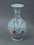 A Chinese porcelain vase decorated with birds in trees. 41 cm high.