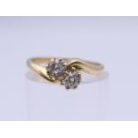 An 18 ct gold diamond cross over ring. Approximate diamond weight 0.4 carat. Ring size K. 2.