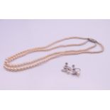 A pair of pearl screw back earrings and a necklace. Necklace 42 cm long, earrings 1.5 cm high.