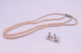 A pair of pearl screw back earrings and a necklace. Necklace 42 cm long, earrings 1.5 cm high.
