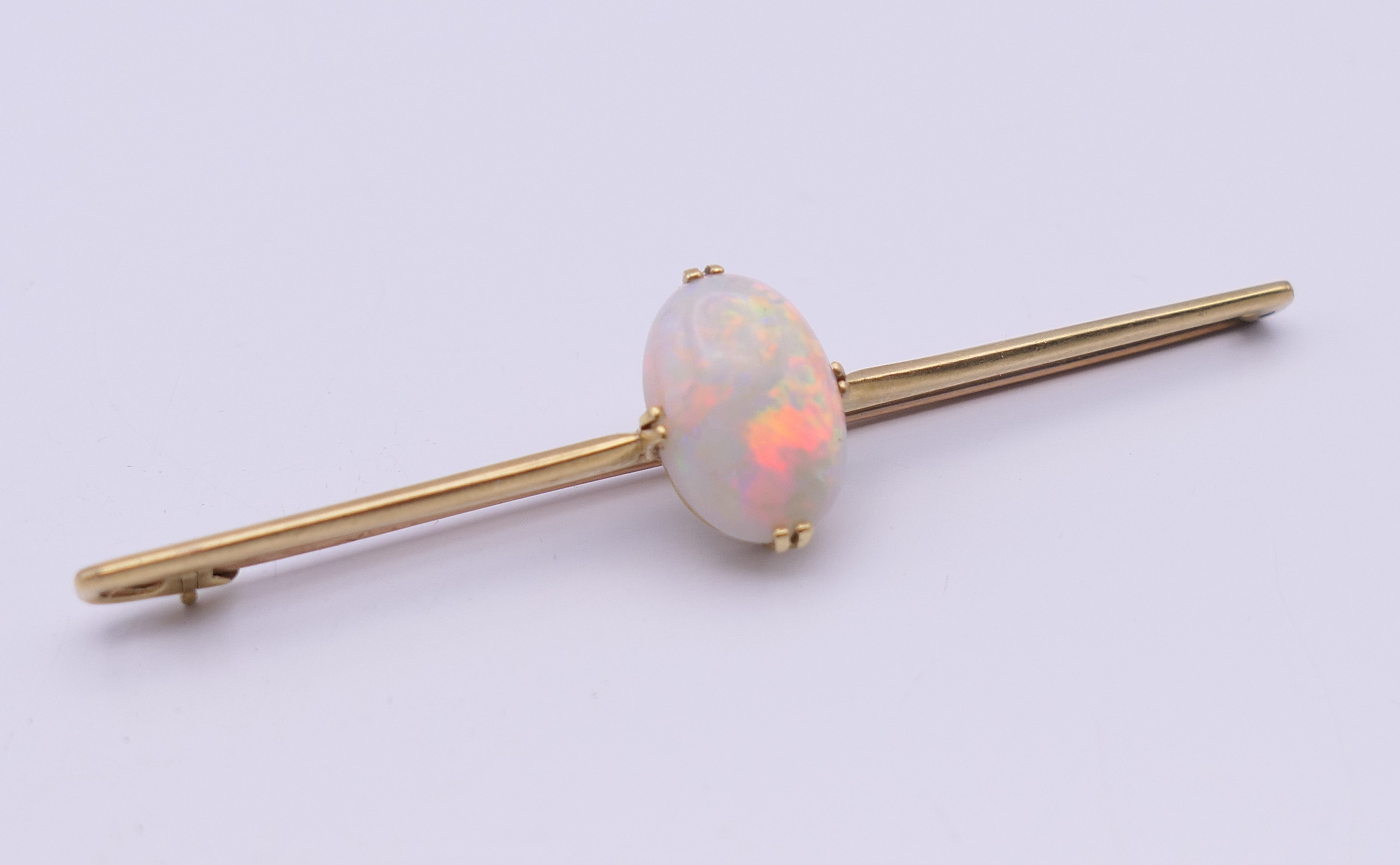 A 15 ct gold opal set bar brooch. 7 cm long, opal 1.5 cm high. 5.3 grammes total weight.