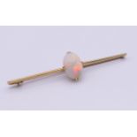 A 15 ct gold opal set bar brooch. 7 cm long, opal 1.5 cm high. 5.3 grammes total weight.