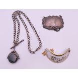 A silver watch chain, fob, a silver decanter label and a porcelain decanter label. The chain 45.