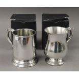 Two boxed pewter tankards. Each 13 cms high.