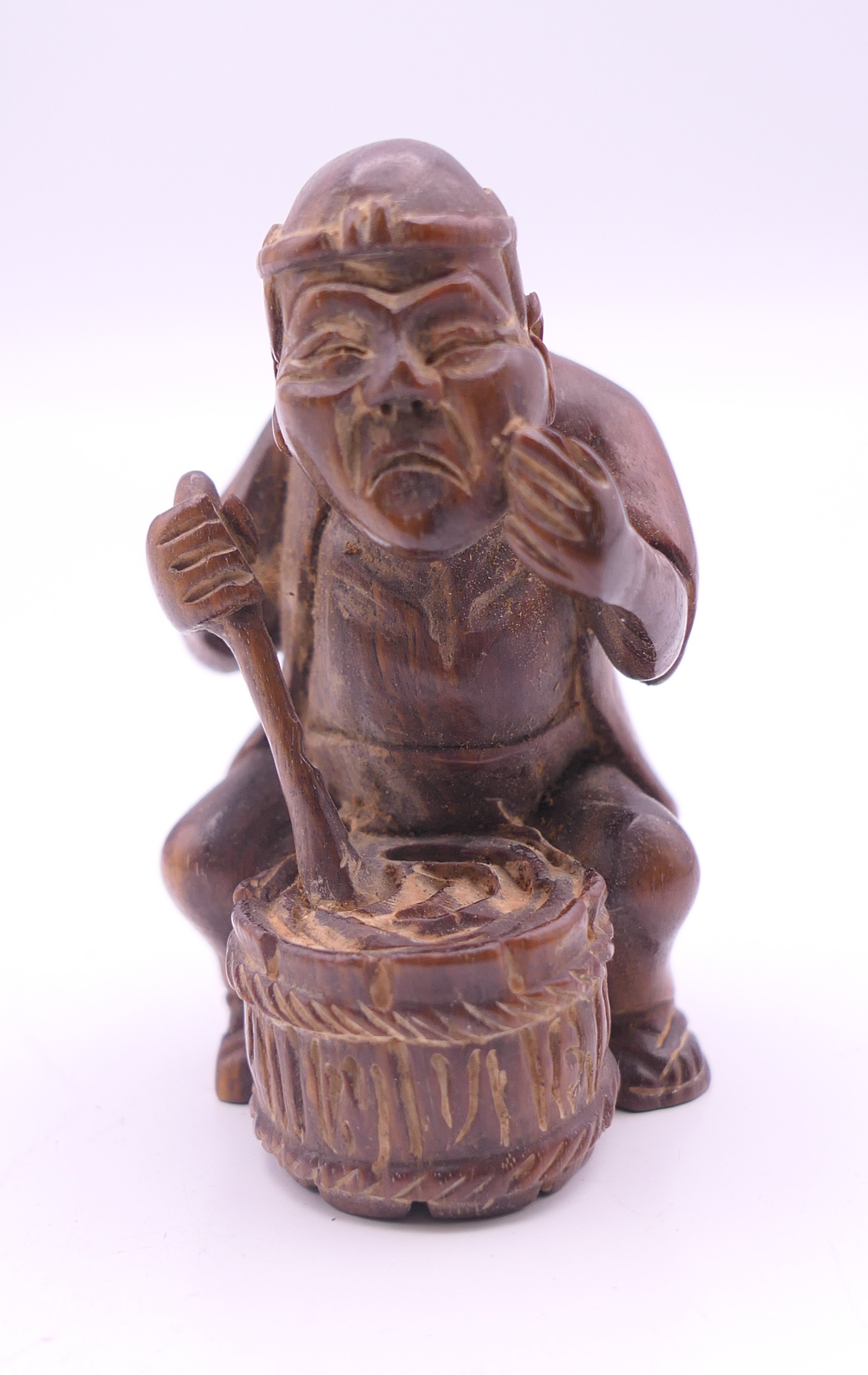 A netsuke formed as a man with a barrel. 6 cm high.