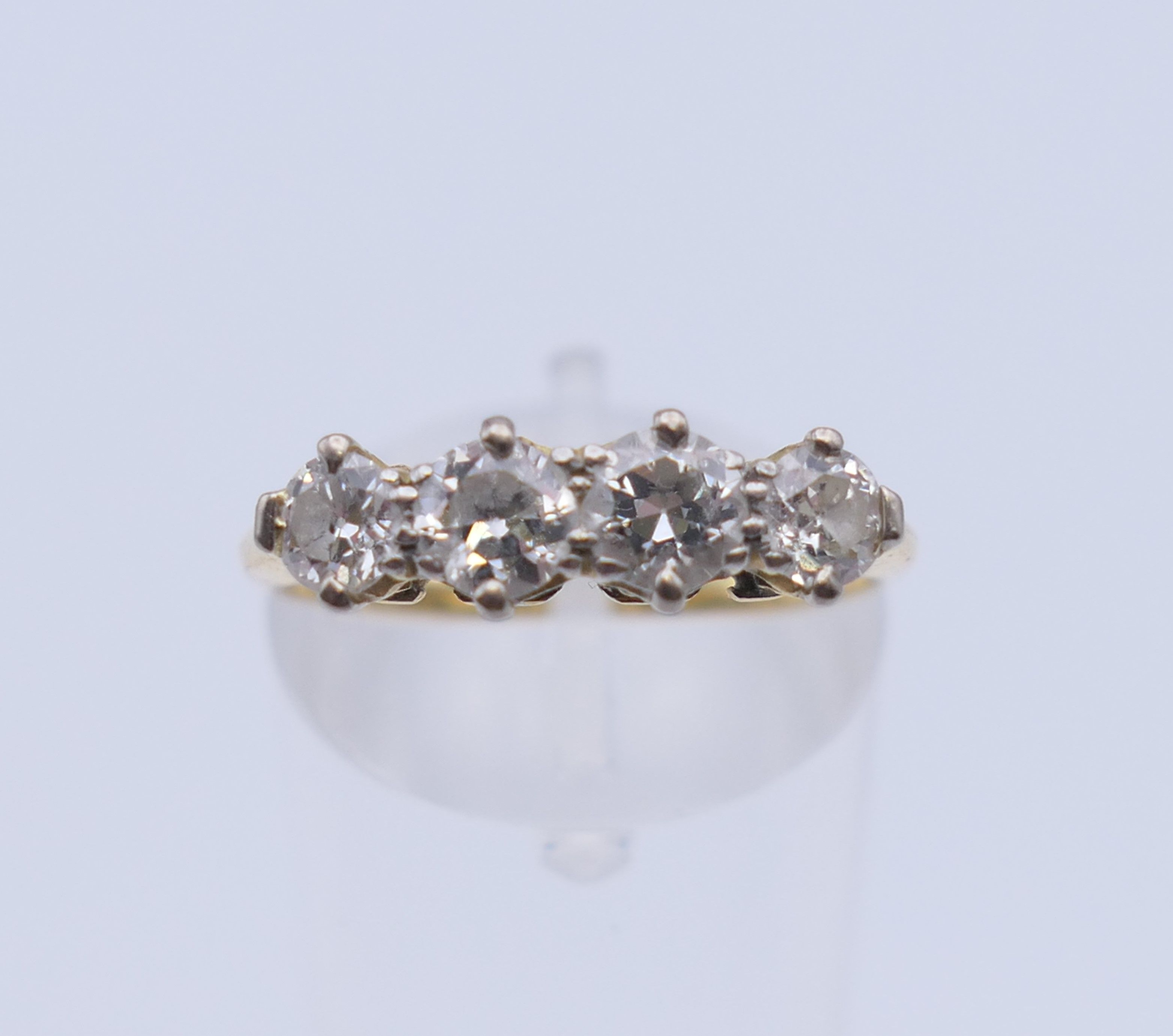An unmarked gold four stone diamond ring. Ring size O. 2.7 grammes total weight. - Image 2 of 6
