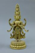 A gilt bronze multi-headed and multi-armed model of a deity. 28 cm high.