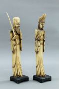 A pair of Oriental carved animal bone figures, on wooden plinth bases.