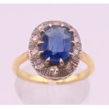 An unmarked gold, blue stone and diamond ring. Ring size M/N. 4.2 grammes total weight.