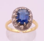 An unmarked gold, blue stone and diamond ring. Ring size M/N. 4.2 grammes total weight.
