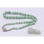A jade bead necklace and a jade tiger form pendant. Bead necklace 42 cm long, pendant 3.5 cm long.