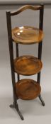 An early 20th century three-tier folding cake stand. 93 cms high.