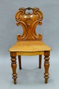 A Victorian oak hall chair.