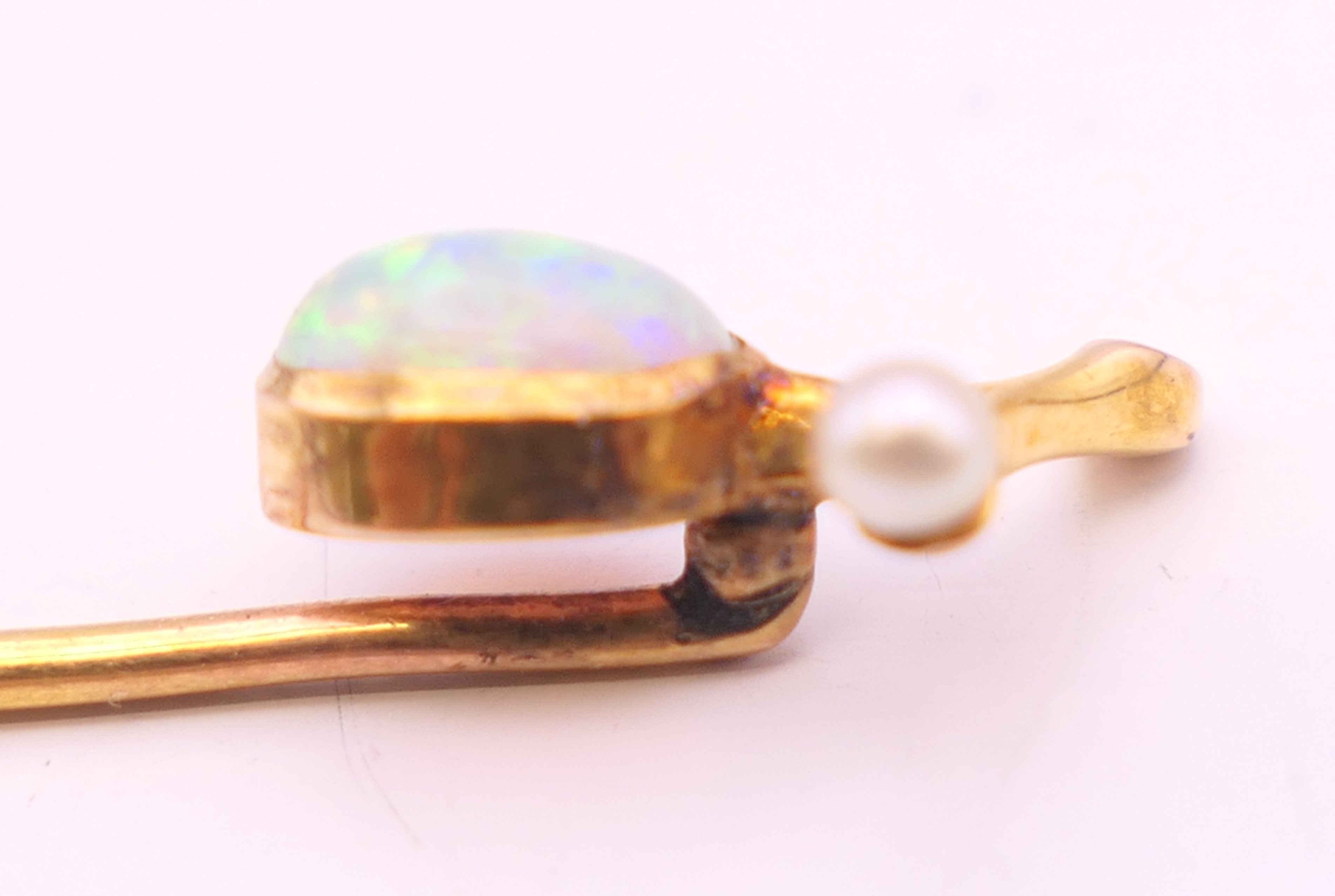 An unmarked 9 ct gold opal and pearl stick pin. 6 cm long. 1.2 grammes total weight. - Image 3 of 5