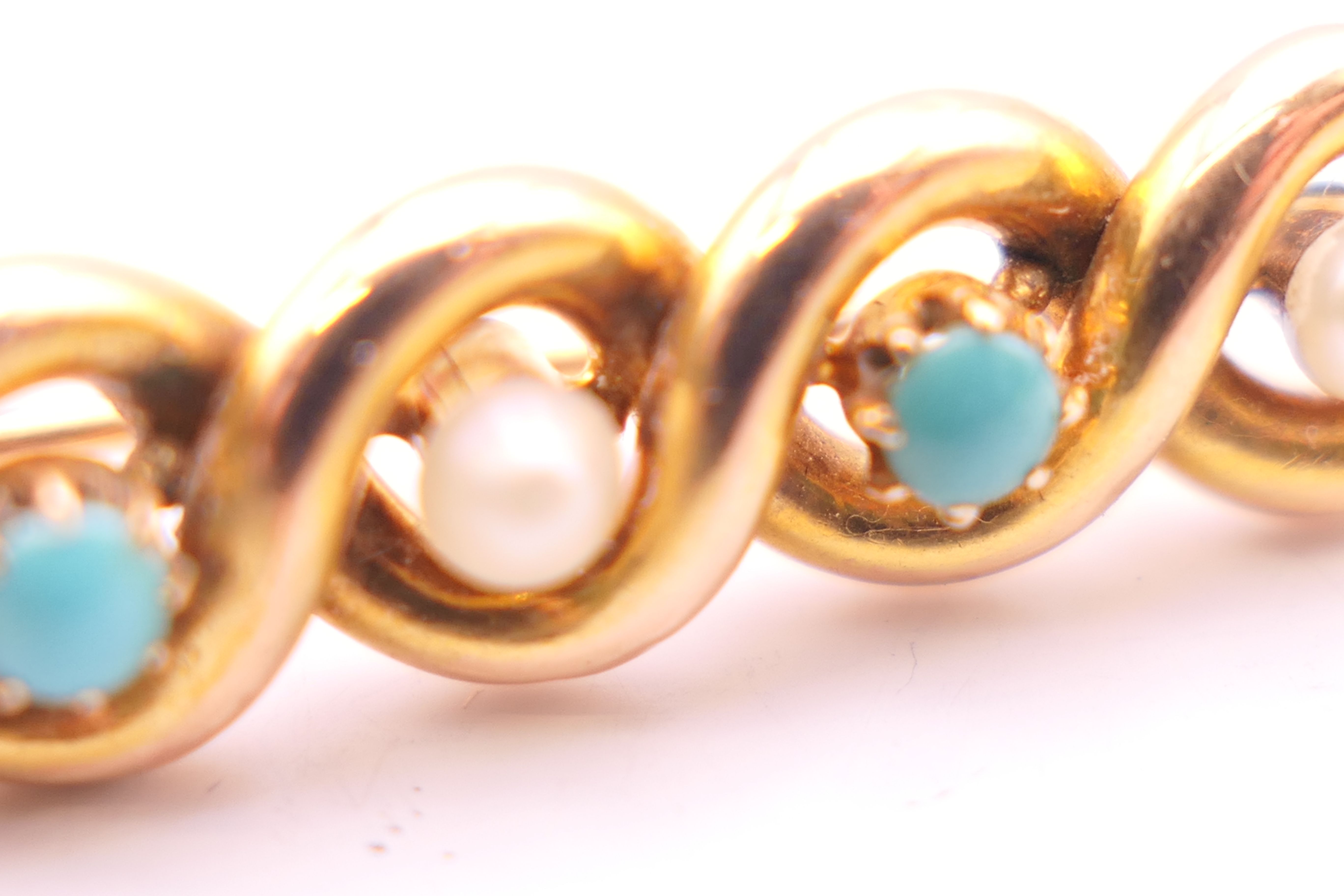 An unmarked gold bar brooch decorated with turquoise and seed pearls. 3.5 cm long. 3. - Image 3 of 3