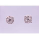 A pair of 9 ct white gold stud earrings. Approximate diamond weight 1.21 carats. 0.75 cm diameter.