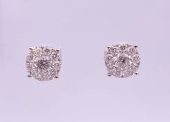 A pair of 9 ct white gold stud earrings. Approximate diamond weight 1.21 carats. 0.75 cm diameter.