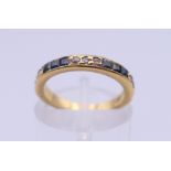 An 18 ct gold diamond and sapphire half eternity ring. Ring size H/I. 2.8 grammes total weight.