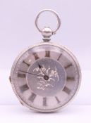 A silver open face pocket watch. 4 cm diameter.