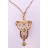 An Art Nouveau 9 ct gold seed pearl and peridot pendant on chain.