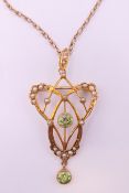 An Art Nouveau 9 ct gold seed pearl and peridot pendant on chain.