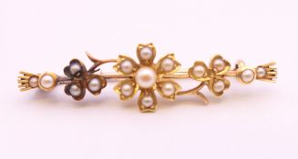 A 9 ct gold bar brooch decorated with flowers and seed pearls. 4.25 cm long. 4.