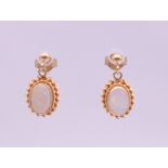 A pair of 9 ct gold opal drop earrings. 1 cm high. 1.4 grammes total weight.