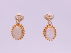 A pair of 9 ct gold opal drop earrings. 1 cm high. 1.4 grammes total weight.