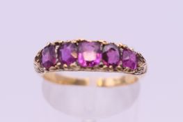 An 18 ct gold five stone ruby ring. Ring size M/N. 3 grammes total weight.