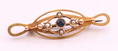 A 9 ct gold bar brooch decorated with a sapphire and seed pearls. 4.5 cm long. 2.