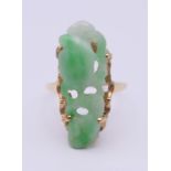 An unmarked gold (tests 18 ct gold) and carved jade ladies ring. Ring size O/P. 4.