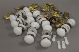 A quantity of porcelain and brass door and drawer handles.