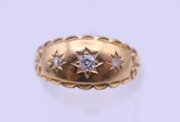A Victorian 18 ct gold three stone diamond gypsy set ring. Ring size N. 2 grammes total weight.