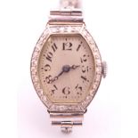 A 1920s ladies wristwatch with diamond set bezel on a 9 ct white gold 1960s bracelet. 1.75 cm wide.