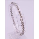 An 18 ct white gold diamond tennis bracelet. Approximate diamond weight 5.6 carats. 19 cm long.