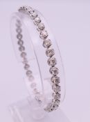 An 18 ct white gold diamond tennis bracelet. Approximate diamond weight 5.6 carats. 19 cm long.