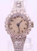 An 18 ct white gold and diamond ladies cocktail watch. 2 cm diameter. 21.7 grammes total weight.