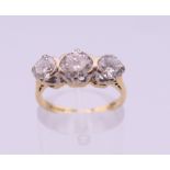 An 18 ct gold three stone diamond ring. Approximate diamond weight 1.7 carats. Ring size L. 3.