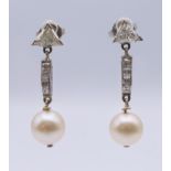 A pair of Art Deco diamond and pearl earrings. 3 cm high.