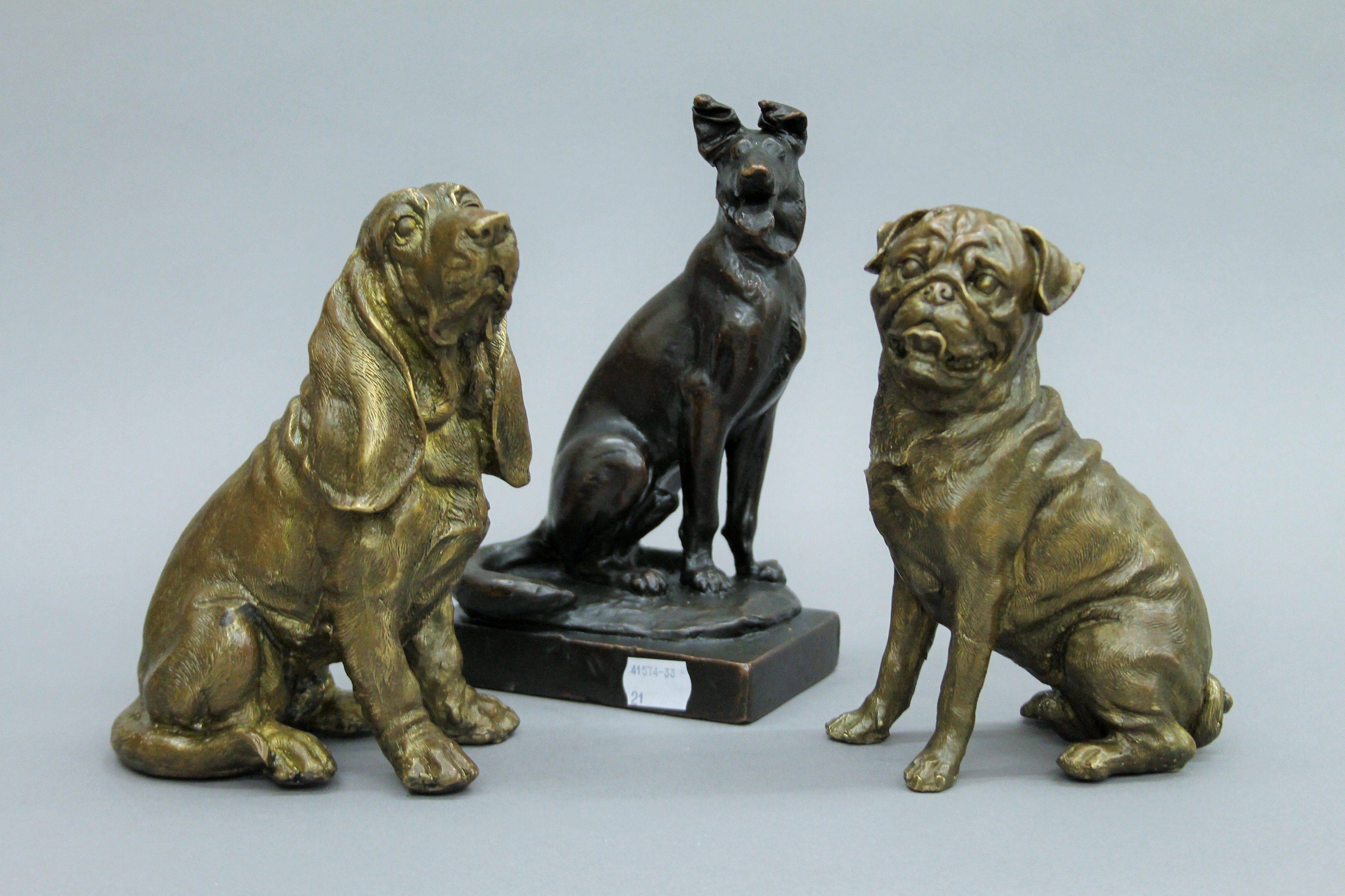 A bronzed figure of a German shepherd, signed Paul Herzel (1876-1956) and two bronze models of dogs.